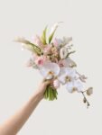 Blush and ivory orchid cascade wedding bouquet held by hand by Anelia Fleur Singapore